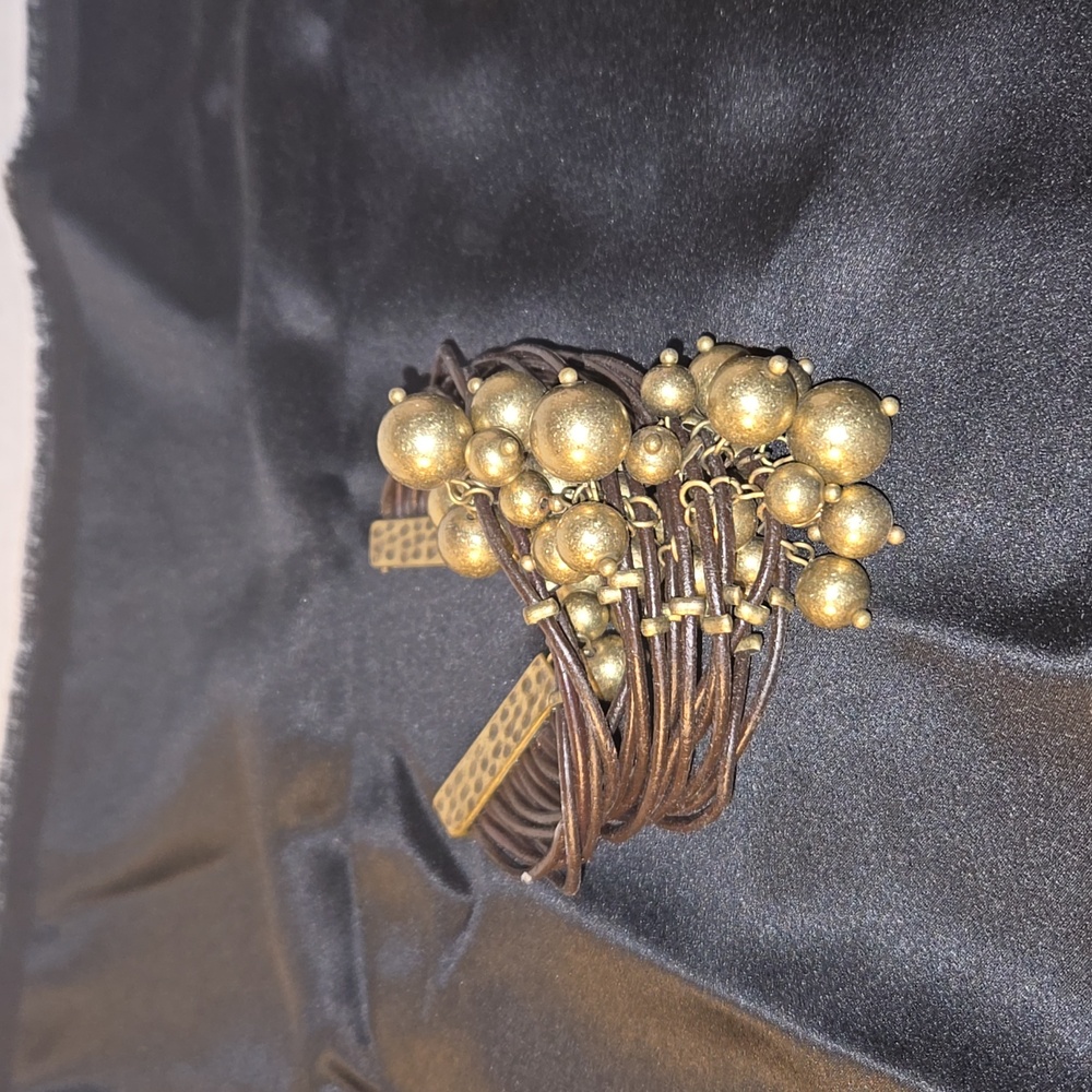 Gold tone and brown leather fascinator cuff.